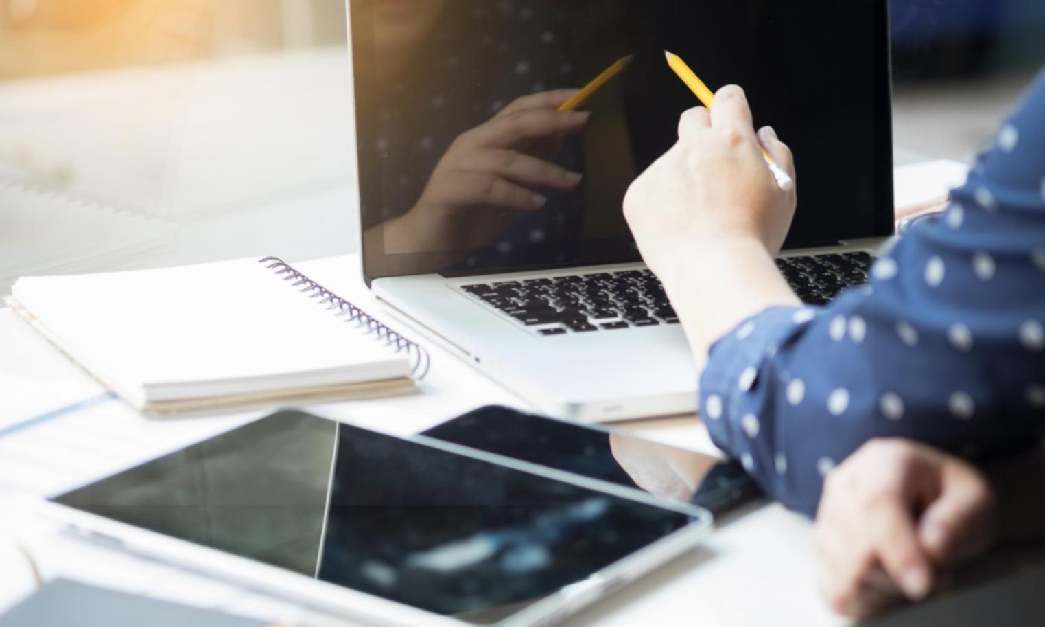 Gemeinsame Lernsession mit Laptops und Finanzunterlagen auf einem modernen Arbeitstisch